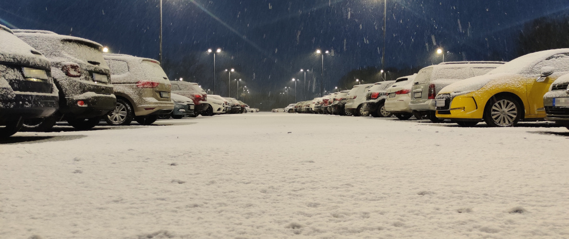 Verschneite Autos auf dem Parkplatz des BWZ